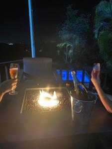 two people sitting around a table with a fire on it at La Kolina Reserve in Ponce