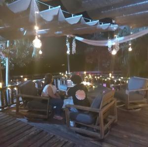 two people sitting at a table in a restaurant at La Kolina Reserve in Ponce
