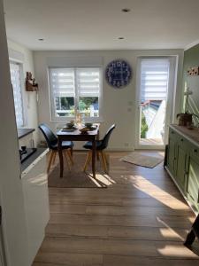 a kitchen and dining room with a table and chairs at Appartement au gré des bulles in Cucq
