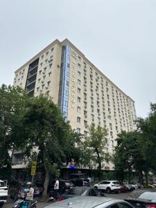 a large building with cars parked in a parking lot at Premium Residence, steps to center Arbat, drinking water as a gift in Almaty