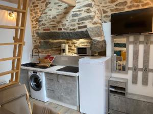 a kitchen with a washer and dryer next to a stone wall at Tiny breyz in Cohiniac