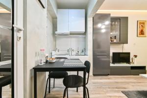 una pequeña cocina con mesa negra y sillas en Tsar Simeon 65 Studio (With Parking space), en Sofía 12 fotos más
