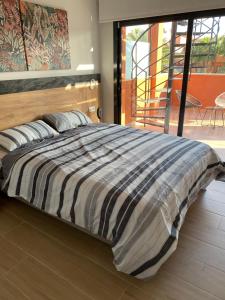 a bed with a striped comforter in a bedroom at Penthouse Palapagolf in Orihuela Costa +30 photos