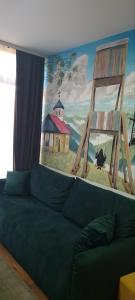 a couch in a living room with a painting on the wall at Apartman Djurdja in Divčibare