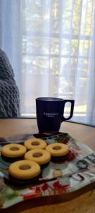 a plate of donuts and a blue cup on a table at Apartman Djurdja in Divčibare