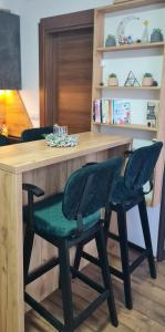 a wooden table with two green chairs in a room at Apartman Djurdja in Divčibare