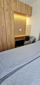 a bedroom with a bed and a wooden wall at Apartman Djurdja in Divčibare