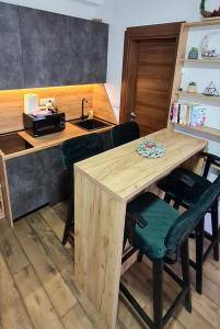 a kitchen with a wooden table with chairs and a sink at Apartman Djurdja in Divčibare