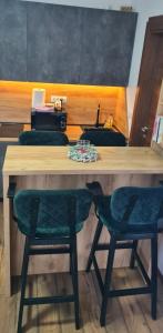 a wooden table with two green chairs in a room at Apartman Djurdja in Divčibare