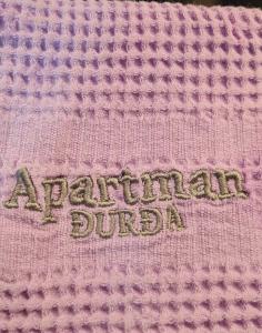a close up of a pink knit blanket with the words american crochet at Apartman Djurdja in Divčibare