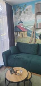 a living room with a blue couch and a table at Apartman Djurdja in Divčibare