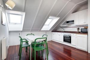 a kitchen with a table and chairs and windows at El Puerto Llanes, apartamento para 4 personas in Llanes +11 photos