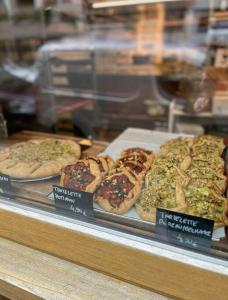 una vitrina con diferentes tipos de pizzas expuestas en Parisian Peaceful Apartment with Stunning View in Montmartre area, en París