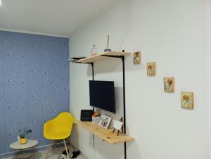 a room with a desk and a tv and a yellow chair at Beira mar 2 in Santos