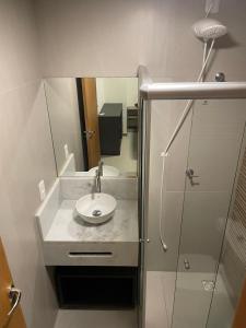 a bathroom with a sink and a shower with a mirror at Apt Tranquilo na Praia do Forte in Praia do Forte +28 photos