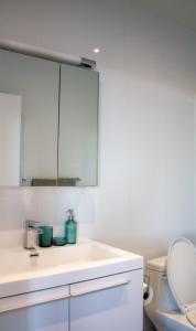a bathroom with a white sink and a toilet at Panoramic Apartment in the old port in Montréal