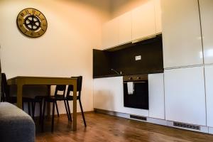 a kitchen with a table and a clock on the wall at Apartmán Leo in Pavčina Lehota
