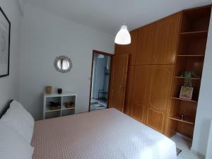 a bedroom with a bed with a wooden headboard and a mirror at Mountain Serenity junior in Konitsa