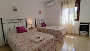 2 Betten in einem Schlafzimmer mit lila Kissen in der Unterkunft Villa 62 by Villamya in El Gastor + 19 Fotos