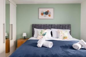a bedroom with a blue bed with white pillows at Home in Patchway in Bristol