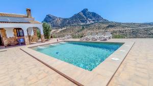 ein Swimmingpool mit Stühlen und Bergen im Hintergrund in der Unterkunft Villa 62 by Villamya in El Gastor