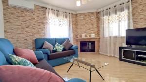 ein Wohnzimmer mit einem blauen Sofa und einem Fernseher in der Unterkunft Villa 62 by Villamya in El Gastor
