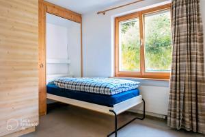 a bed in a room with a window at Pool & Sauna Wellness Charming Swiss style chalet! in Salouf +30 photos