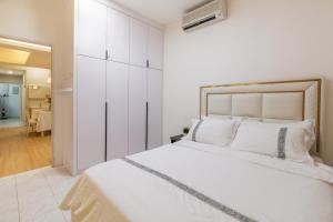 a white bedroom with a large bed and a hallway at Nibong Tebal Beautiful Homestay Retreat with WiFi & Netflix in Nibung Tebal