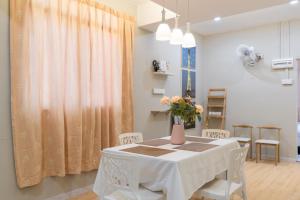 a dining room with a table with a vase on it at Nibong Tebal Beautiful Homestay Retreat with WiFi & Netflix in Nibung Tebal