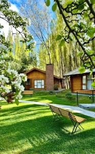 a park bench sitting in the grass in front of a house at Santa Monica Aparts in El Calafate