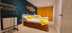a bedroom with a bed with yellow pillows at Glamorous Apartment at Christchurch Park in Ipswich