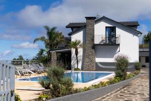 a villa with a swimming pool and a resort at Casa das Proteas in São Jorge