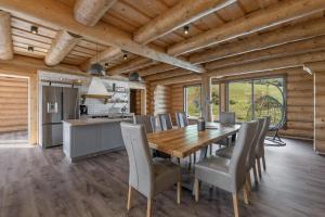 a kitchen and dining room with a wooden table and chairs at Chalet Liptov Izipovce in Ižipovce