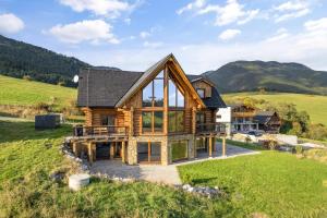 a house on a hill with mountains in the background at Chalet Liptov Izipovce in Ižipovce