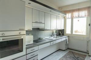 a kitchen with white cabinets and a sink and a window at Lapland Aurora Suite by BookLapland in Rovaniemi