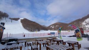 a group of picnic tables in the snow on a ski slope at Casa di Sara in Pescasseroli