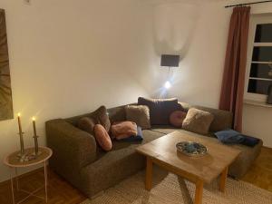 a living room with a couch with pillows and a table at Im schönen Naheland bei Kirn in Meckenbach