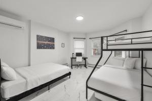 ベイヨンにあるCozy Urban Escape I Near NYCの二段ベッド2台と机のある寝室