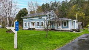 een blauw huis met een bord ervoor bij The Tannery House in Claryville