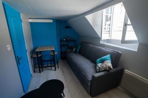 un salon avec un canapé et une fenêtre dans l'établissement LA PERLE APPART - PLEIN CENTRE VILLE Orléans, à Orléans 2 autres photos