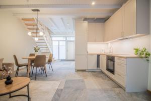 cocina con armarios blancos, mesa y comedor en Lai Residence Apartment 1, en Tartu