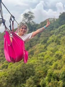 a woman in a pink dress swinging in a hammock at LA CASA EN EL AIRE - Abejorral in Abejorral