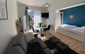 a living room with a couch and a bed and a table at Central & Cosy in Luchon