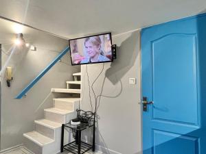 une télévision sur un mur dans une pièce avec des escaliers dans l'établissement LA PERLE APPART - PLEIN CENTRE VILLE Orléans, à Orléans