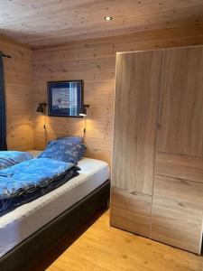 a bedroom with a bed and a wooden wall at Moderne Rorbu helt i sjøkanten in Hauge +38 photos