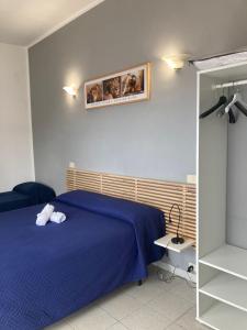 a bedroom with a blue bed and a mirror at SIMPLY INN close to TIVOLI in Marcellina