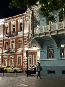 una persona caminando por una calle frente a un edificio en Apartment Gudiashvili square, en Tiflis