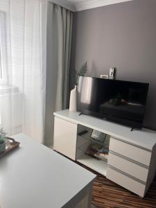 a living room with a television on a white entertainment center at Apartament Na Starówce VII in Pszczyna +22 photos