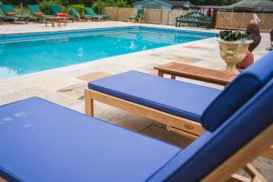 a swimming pool with two blue lounge chairs next to it at Potton Hall in Saxmundham +23 photos