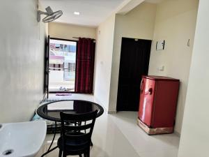 a room with a small table and a red refrigerator at COCHIN HOMES in Cochin
